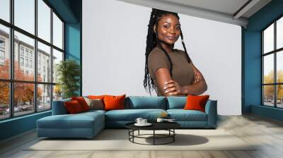 Portrait of african woman with arms folded standing over gray background Wall mural